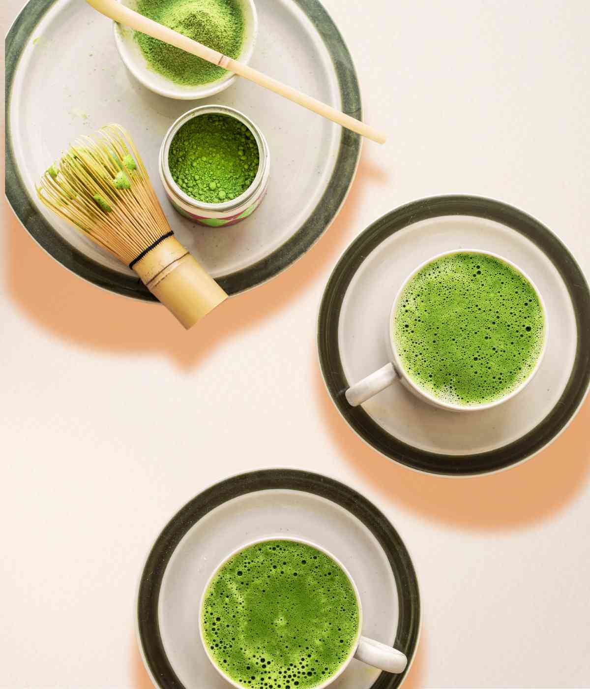 Zwei Matcha Latte mit Matcha Pulver und Bambusbesen