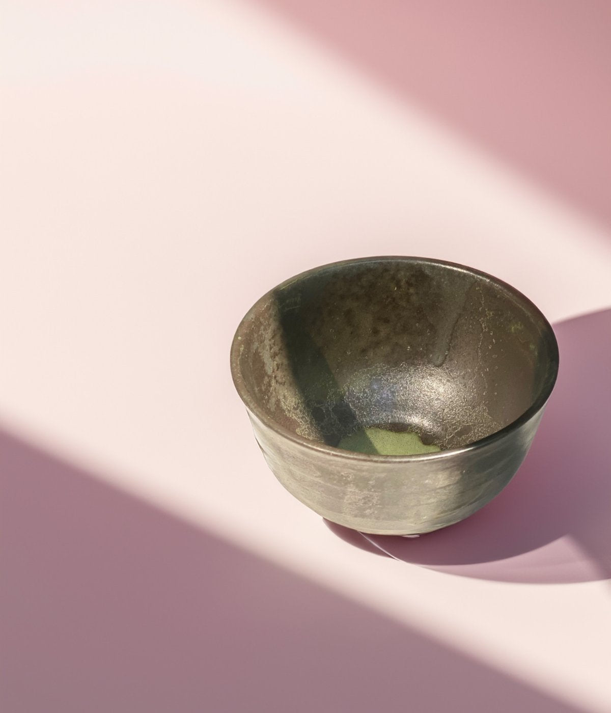 Leere Schale mit Matcha-Resten auf hellem Untergrund.