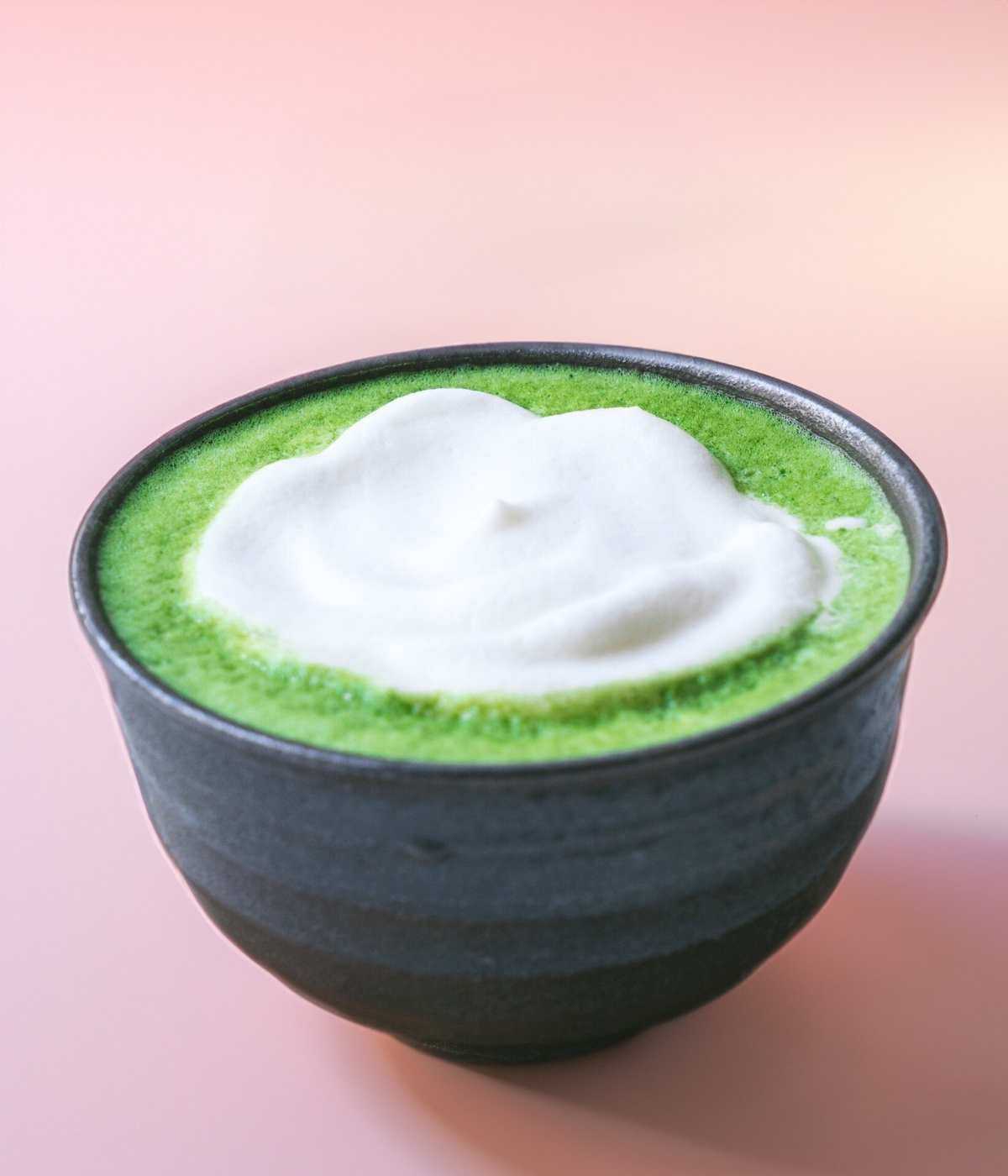 Matcha Schale mit cremigem, schaumigem Matcha Latte auf hellem Untergrund.