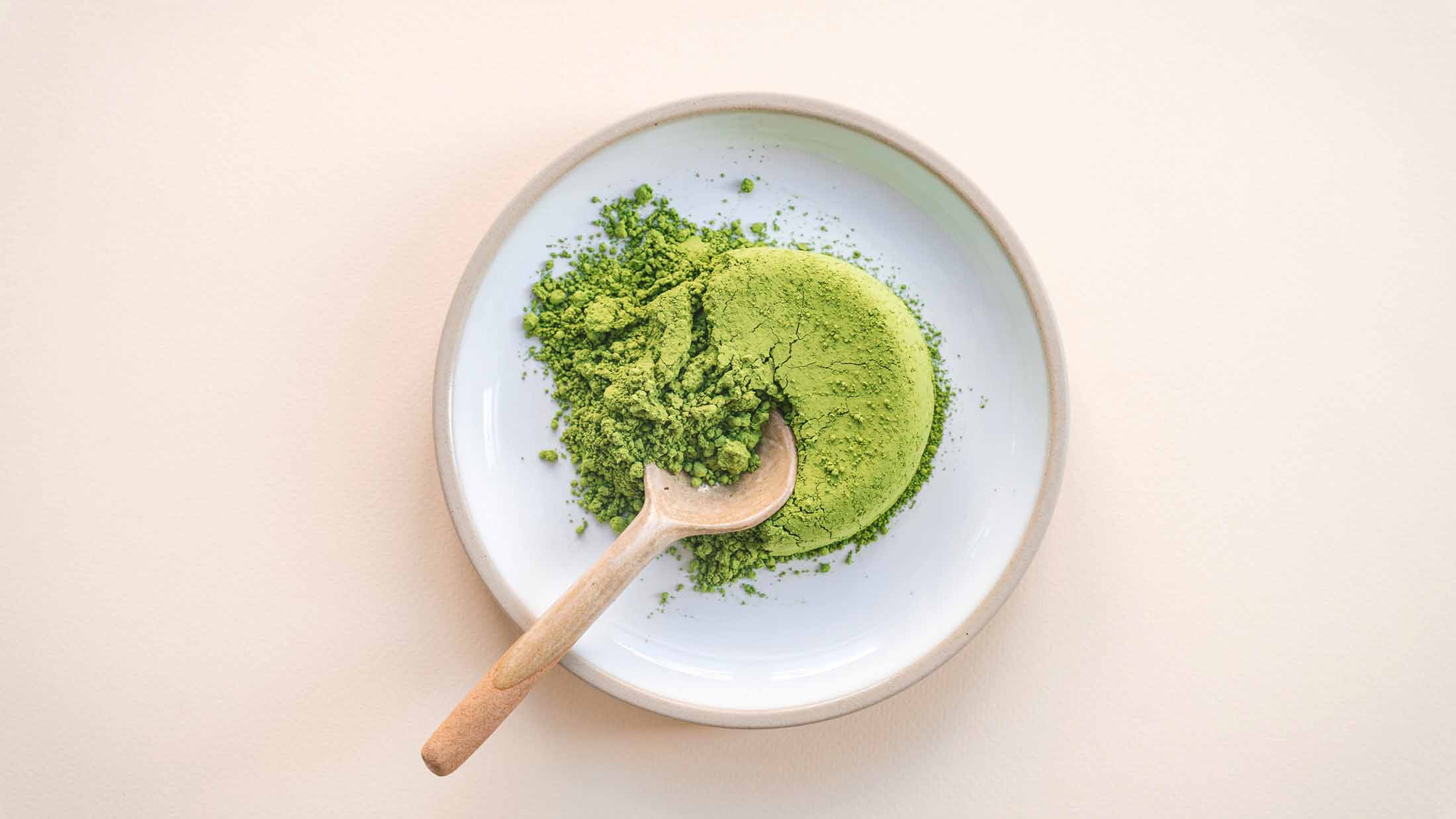 Matcha powder and wooden spoon in a bowl