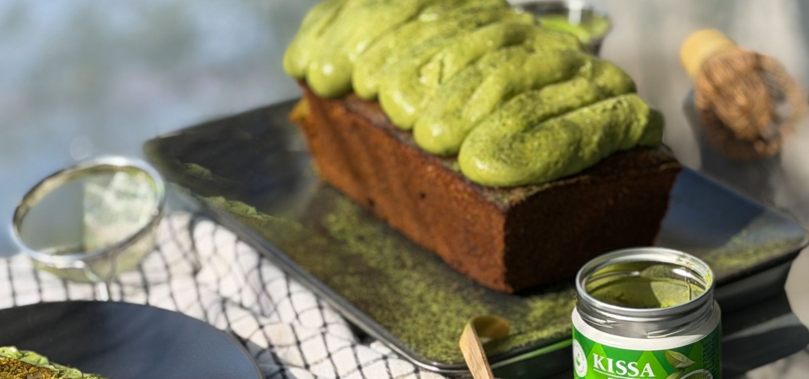 Matcha Carrot Cake festlich angerichtet zwischen Matcha Accessoires