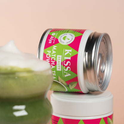 Matcha in a bowl, next to it a bamboo whisk, bamboo spoon and a KISSA Matcha Beauty