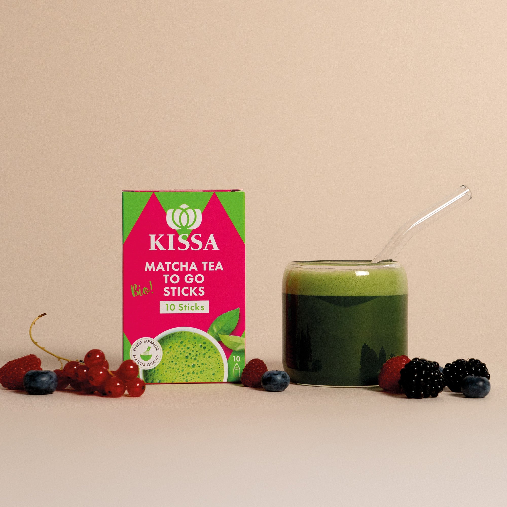 Matcha Stick Box neben einem Matcha, davor liegen Waldbeeren