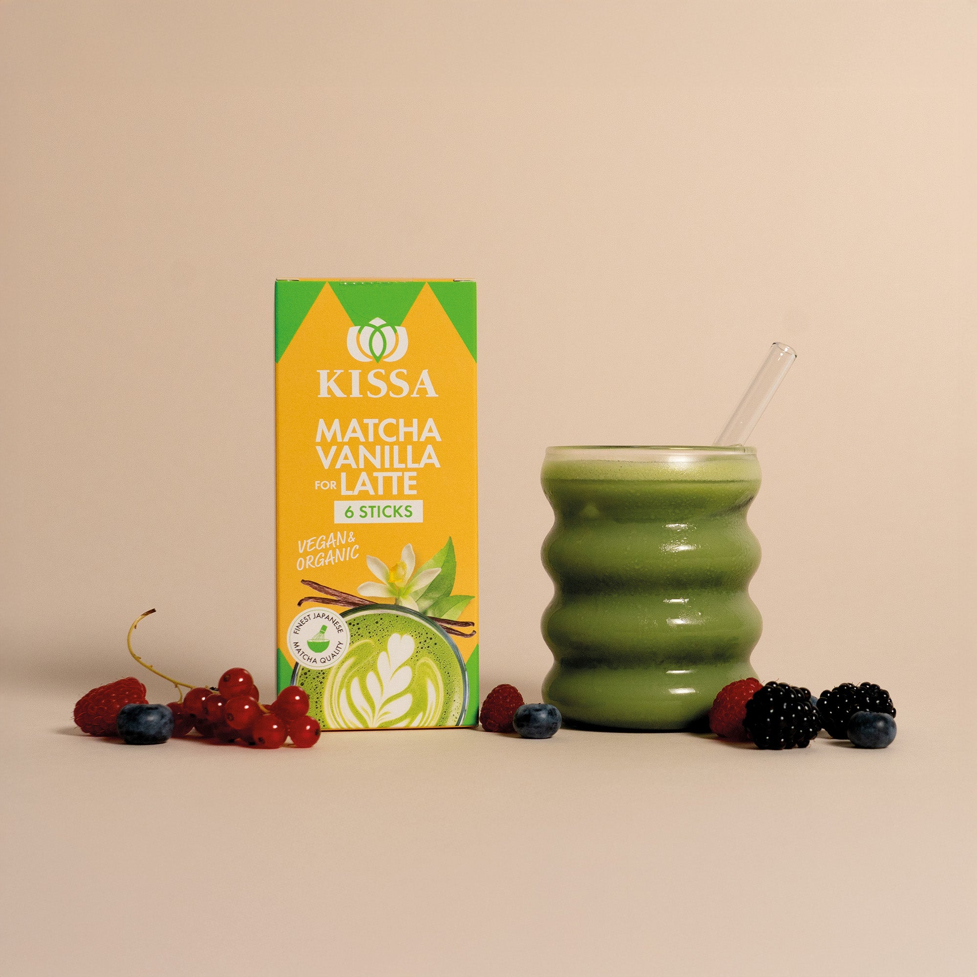 Matcha Stick Box neben einem Matcha Latte, davor liegen Waldbeeren
